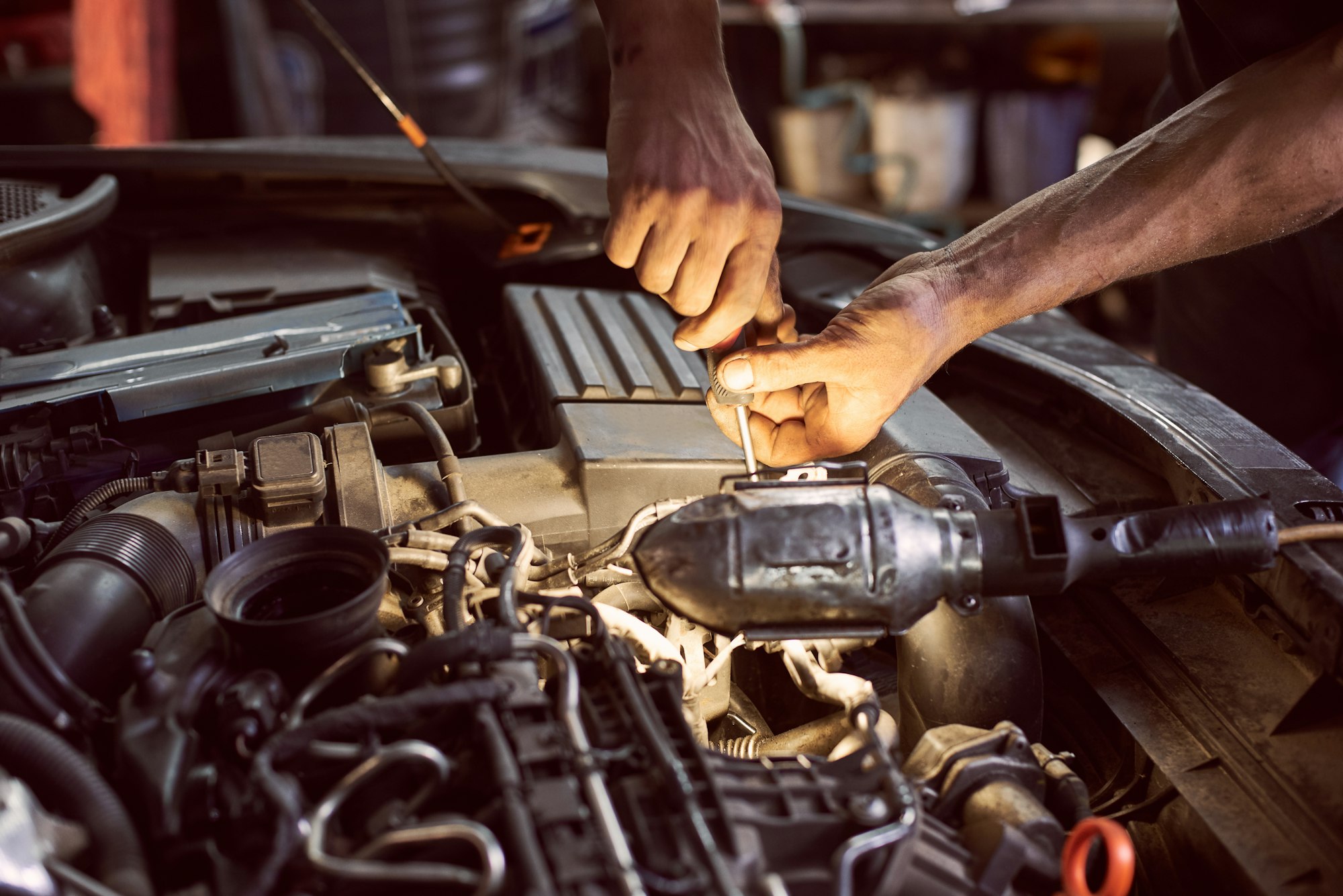 Repairing diesel engine with screwdriver and flashlight helping.